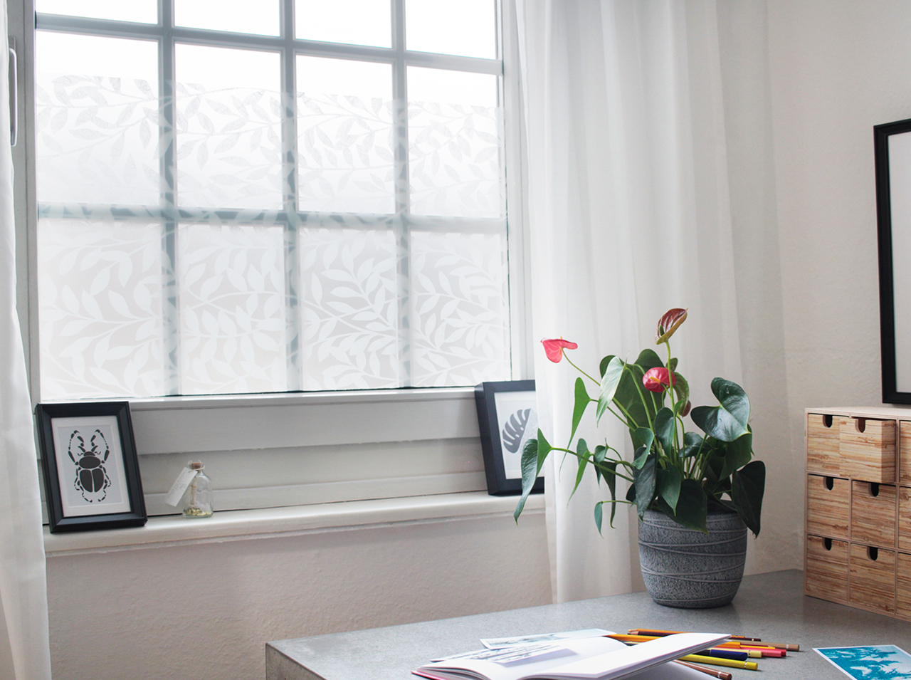 Fensterfläche für effektiven Sichtschutz mit d-c-fix® Fensterfolie static premium Jane in modernem Design von Blätterranken beklebt.