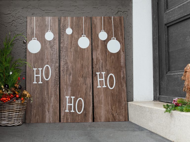 Drei Holzlatten mit d-c-fix® Klebefolie Rustik in kerniger Holzoptik beklebt und mit weihnachtlichen Ornamenten aus weißer Klebefolie dekoriert.