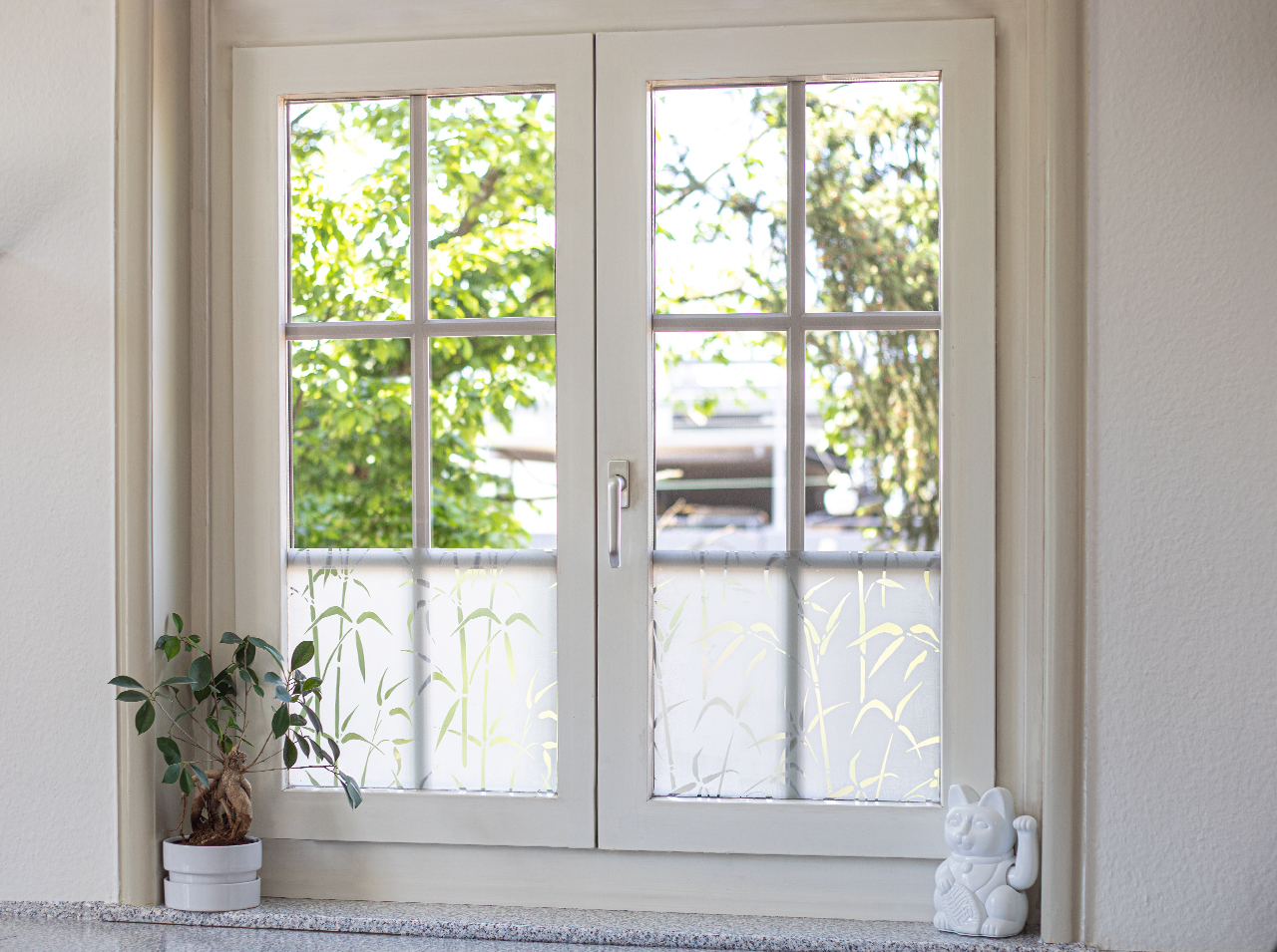 Window covered with opaque window foil in bamboo look for privacy.