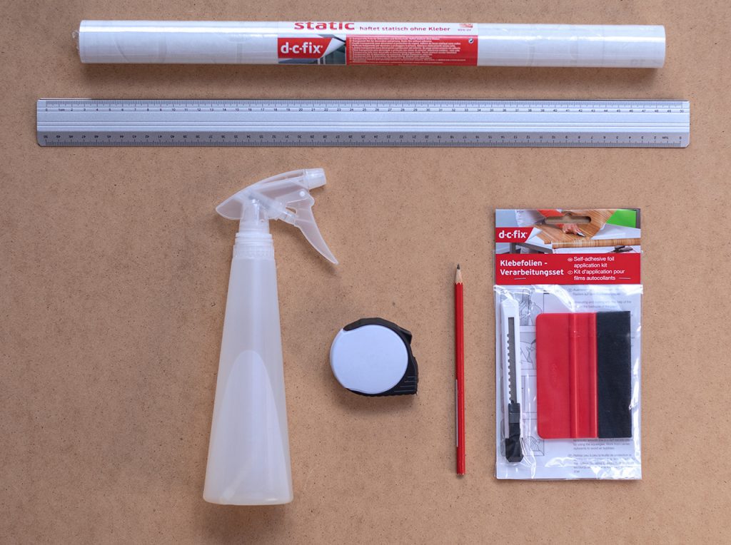 Static Bamboo, Metalllineal, Tuch, Sprühflasche, Maßband, Stift, Cutter und Rakel liegen auf einer Schneidematte