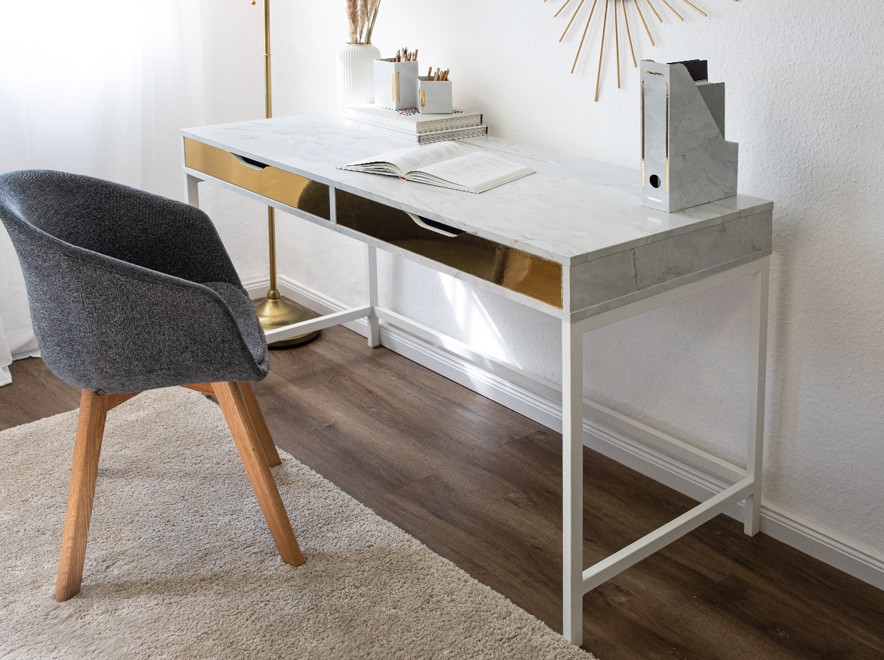 Schreibtisch mit Tischfläche, die mit Klebefolie in weißer Marmoroptik neu beklebt und gestaltet wurde.