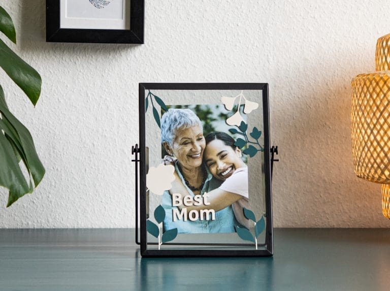 A transparent photo frame with a photo, decorated with flowers made from adhesive foil.