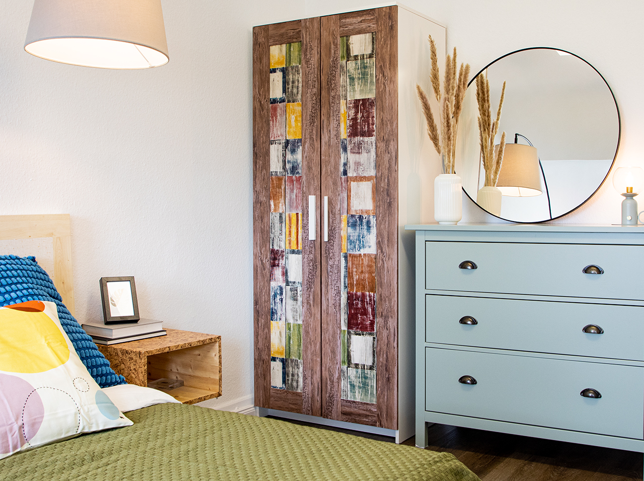 Drzwi szafy oklejone foliami samoprzylepnymi w kolorowym stylu vintage oraz o wyglądzie drewna przywodzą na myśl nadmorski domek.