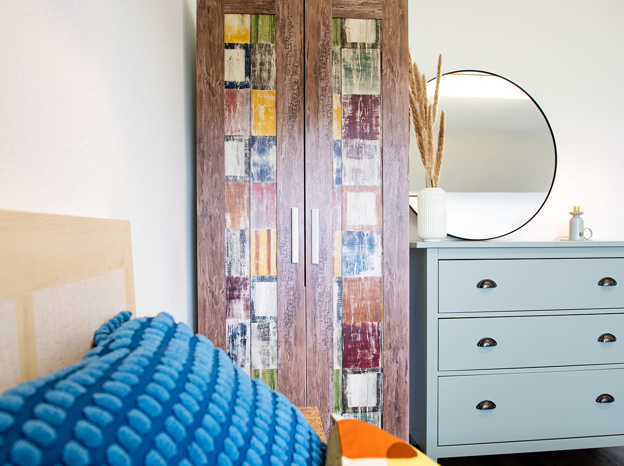 Doors of closet pasted with adhesive foils in colorful vintage look and wood look similar to a beach house.