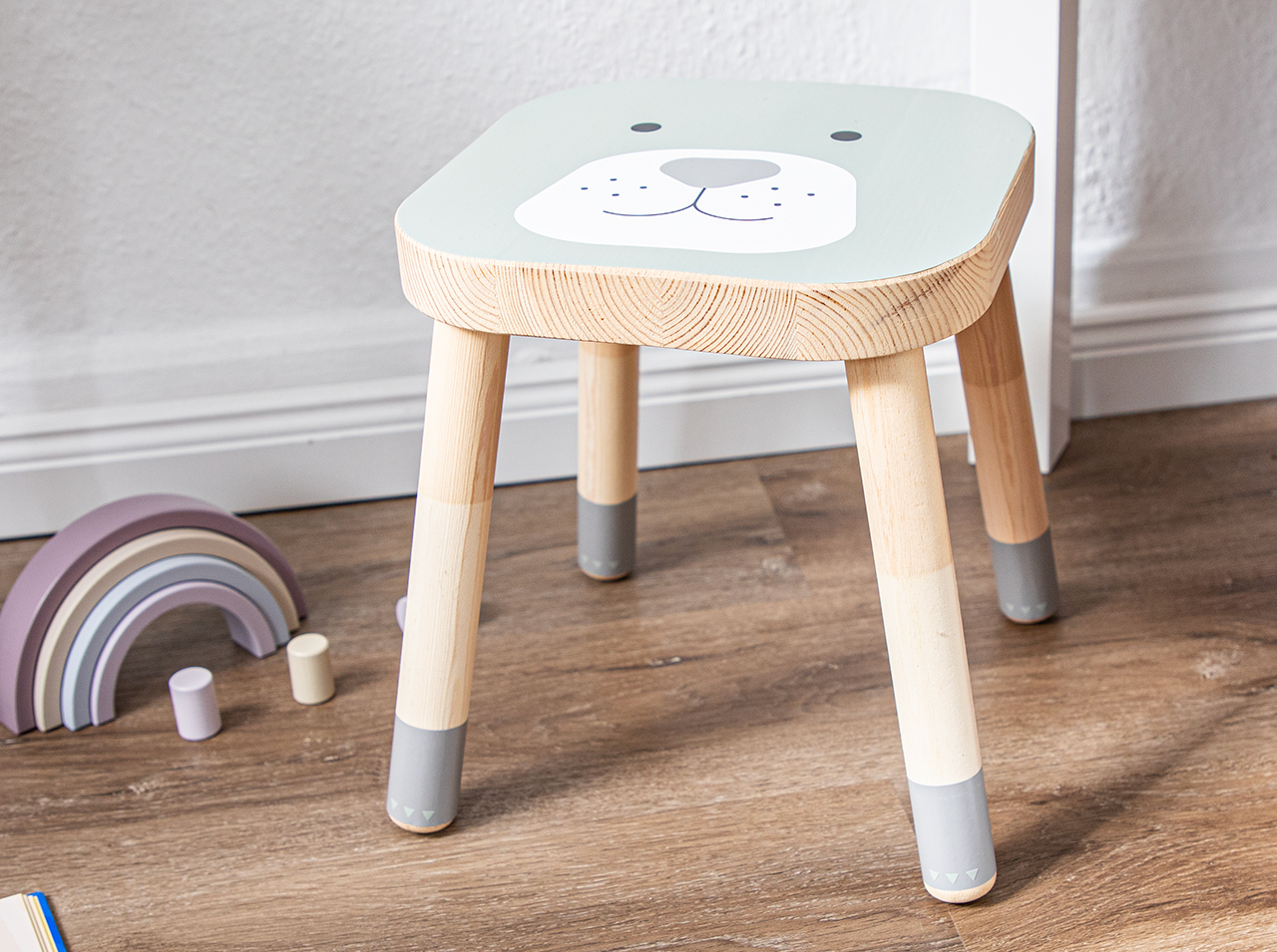 Low stool for children with friendly animal face on the seat.