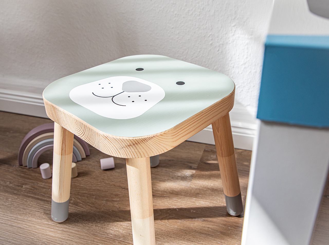 Low stool for children with friendly animal face on the seat.