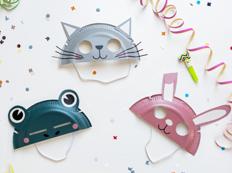 Varie maschere di animali colorate realizzate con piatti di carta e ricoperte con pellicola colorata.